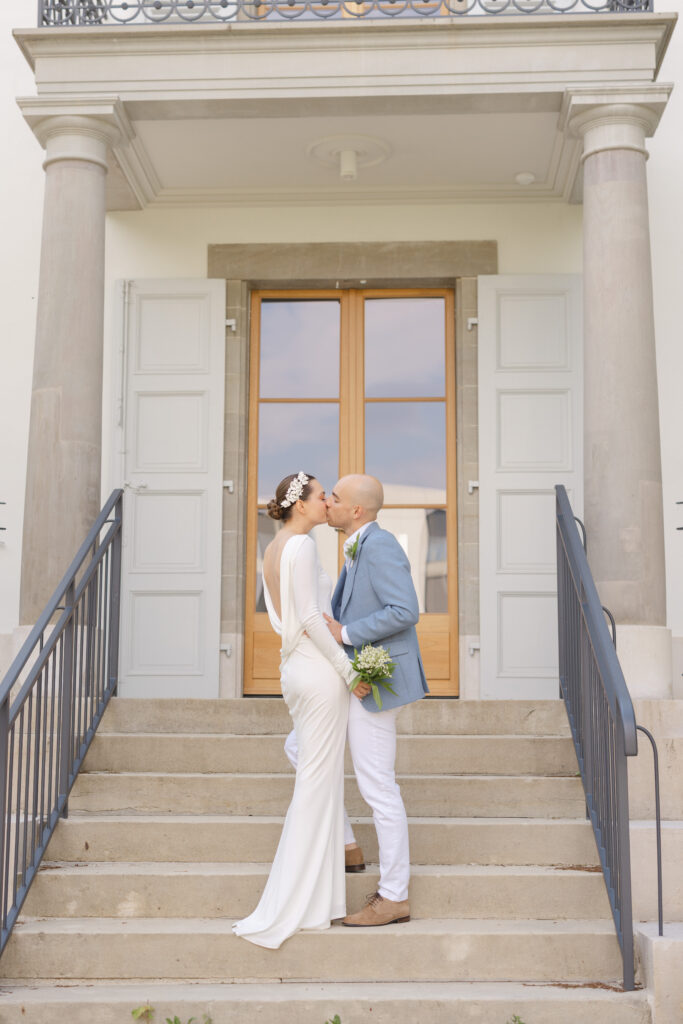 Bride and groom kissing on steps outside Mairie de Lancy Geneva civil wedding