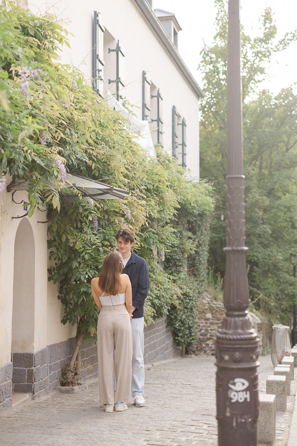 Couple playing around lamppost with wisteria in background during couple photo session Montmartre Paris