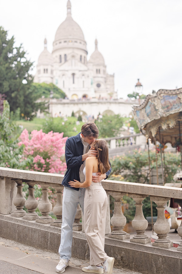 Couple kissing in front of Sacré Coeur during couple photo session Montmartre Paris