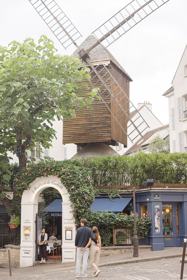 Couple posing in front of Moulin Rouge during couple photo session Montmartre Paris