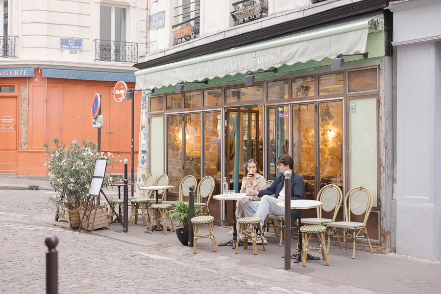 Couple sitting at café terrasse in Montmartre during couple photo session Paris