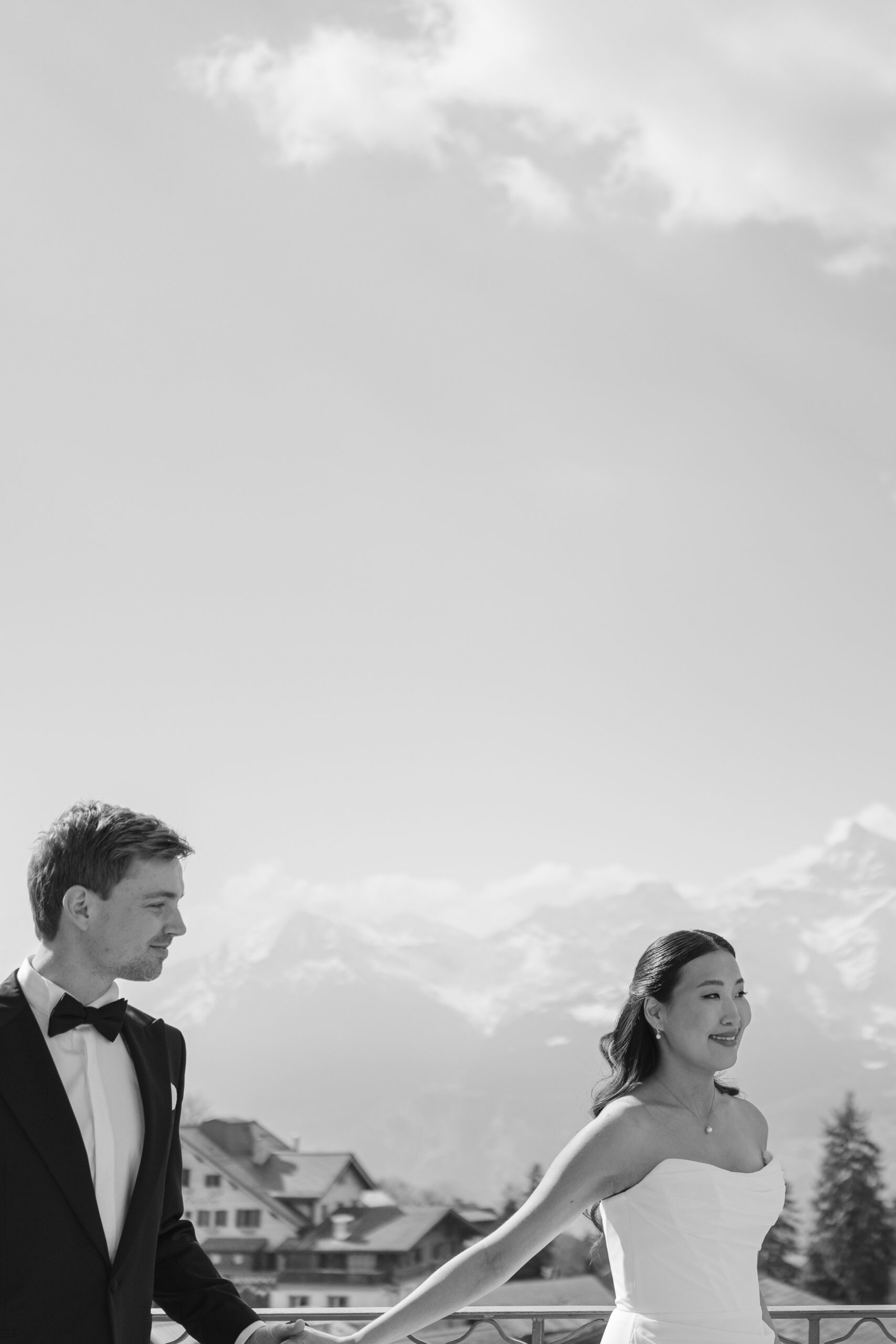Bride and groom holding hands in the Swiss Alps, black and white elopement portrait