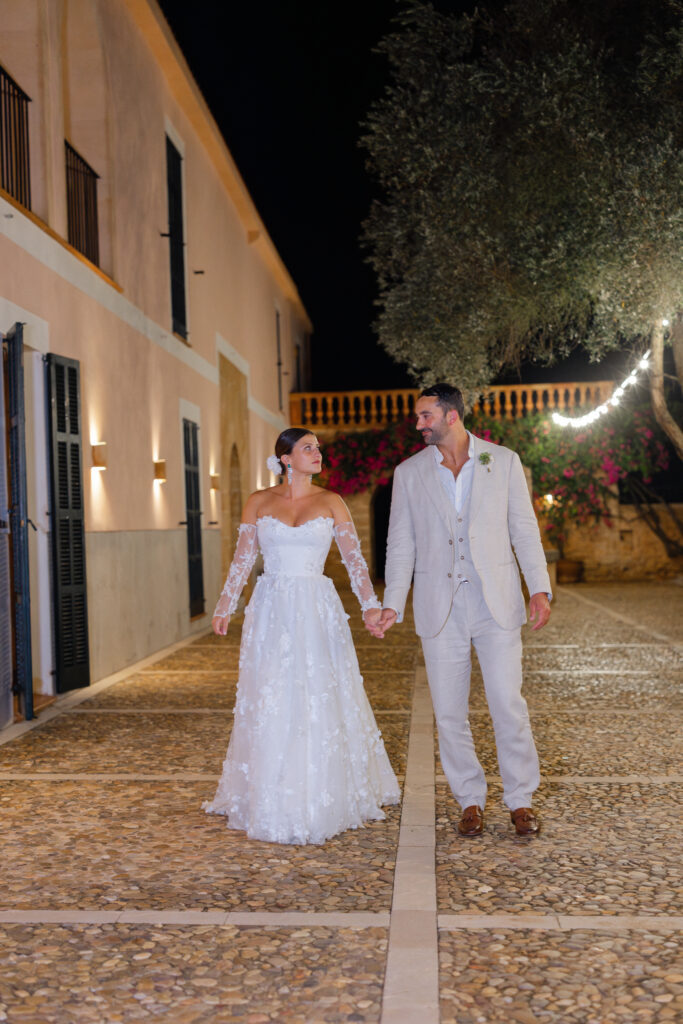 Bride and groom walking along illuminated path at night at Son Donblon Mallorca