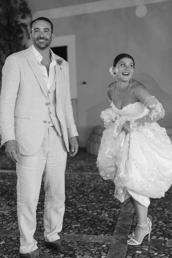 Black and white portrait of laughing bride and groom at night, rainy wedding Mallorca