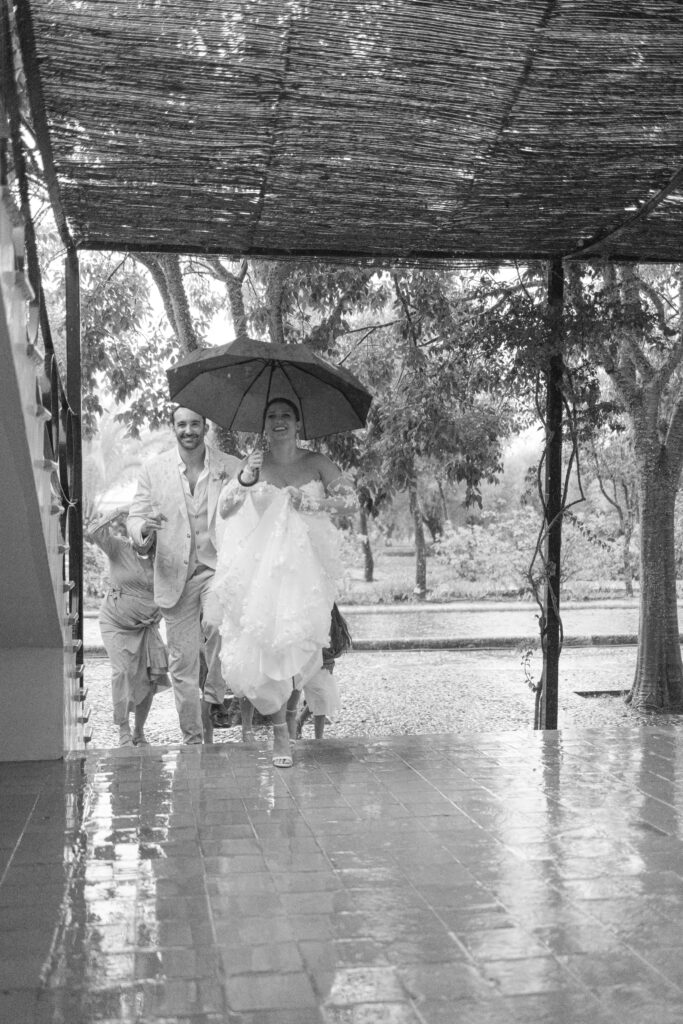 Black and white photo of couple under umbrella rainy wedding Mallorca